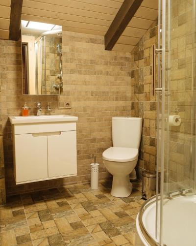 a bathroom with a toilet and a sink and a tub at BRB Park Hotel in Vizhenka