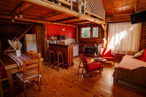 a kitchen and living room with red walls and wooden floors at Namasté Cabaña Tandil in Tandil