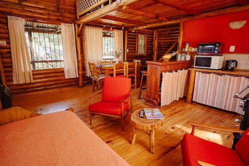 una sala de estar con mesa y sillas en una cabaña en Namasté Cabaña Tandil en Tandil