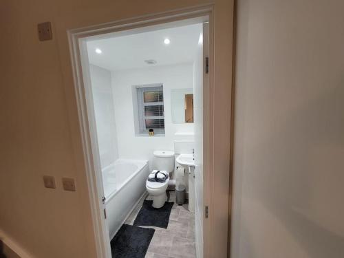 e bagno con servizi igienici, vasca e lavandino. di New build home with WI-FI, Smart TV, dedicated office floor, large terrace and Free parking a Milton Keynes