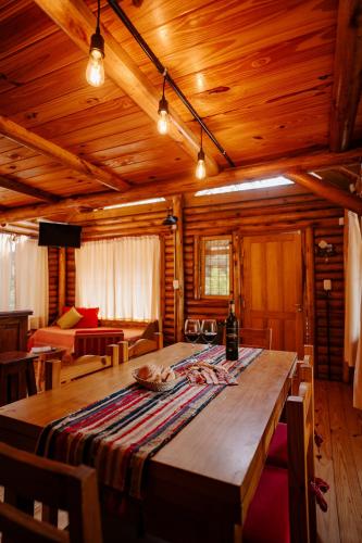 a large wooden table in a room with a couch at Namasté Cabaña Tandil in Tandil