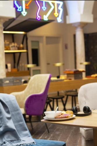a table with a plate of food and chairs at room00 Salvador Hostel in Seville