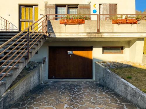 a building with a wooden door and stairs at Mini appartamento panoramico in Sùtrio