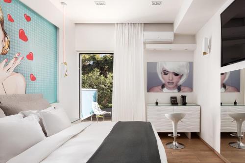 a bedroom with a bed and a wall with a picture of a woman at Mirada Hotel in Athens