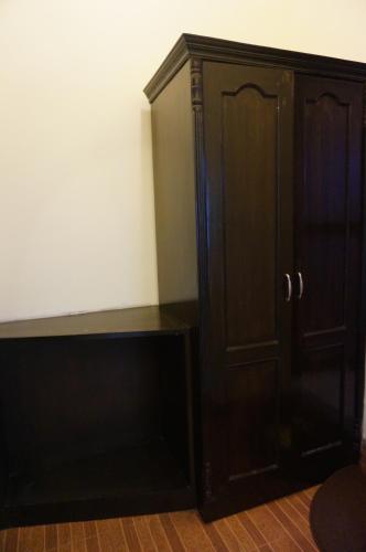 a dark wooden cabinet sitting next to a wall at New Annapurna Guest House in Pokhara