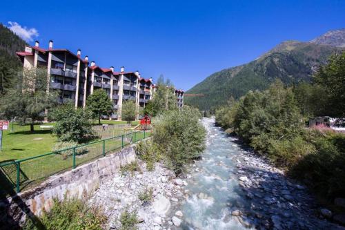 einem Fluss vor einem Resort mit einem Gebäude in der Unterkunft Cocon en face du Grands Montets in Chamonix-Mont-Blanc