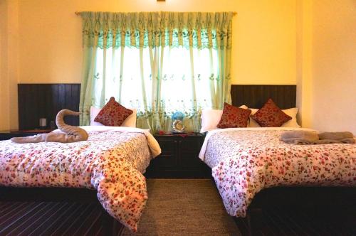 a bedroom with two beds with stuffed animals on them at New Annapurna Guest House in Pokhara