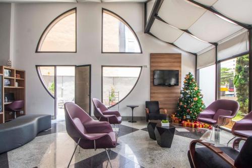 una sala de estar con un árbol de Navidad y sillas moradas en Saint Lawrence - 108, en São Paulo