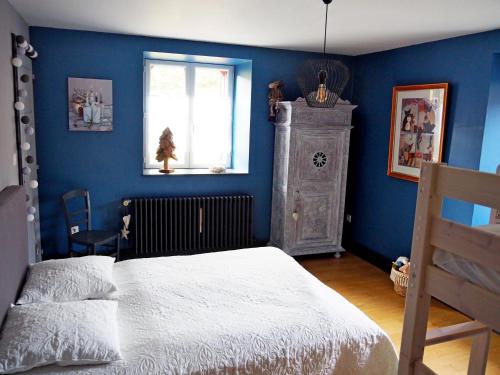 a blue bedroom with a bed and a window at Appartement Maison Vosgienne La Bresse Centre in La Bresse