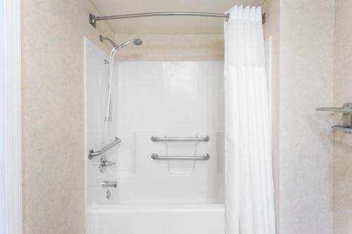 een douche met een wit douchegordijn in de badkamer bij Wingate by Wyndham Joliet in Joliet