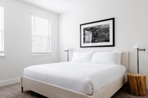 a white bedroom with a large bed with white pillows at Kasa Southside Jacksonville in Jacksonville