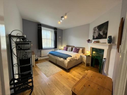 1 dormitorio con 1 cama y chimenea en 10 Grove St - Bath Holiday Suites en Bath