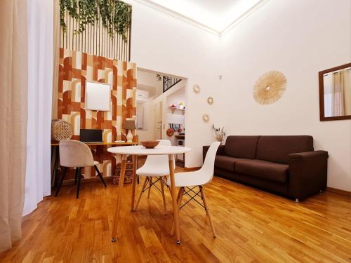a living room with a table and a couch at Natoli Apartments in Palermo