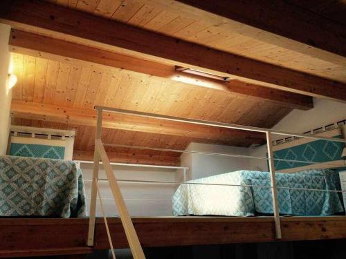 Cette chambre dispose de 2 lits superposés et de plafonds en bois. dans l'établissement El Dorado Luxury Apartment, à Alghero