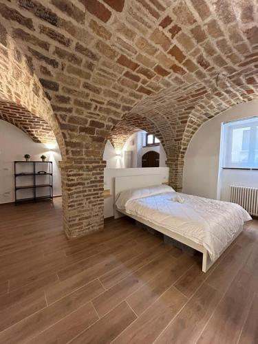 a bedroom with a bed in a brick wall at CASA GAH in Ripatransone