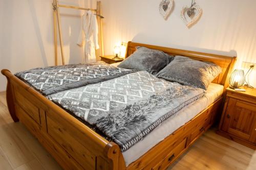 1 dormitorio con 1 cama de madera y 2 almohadas en Prázdninový dům Valdík, en Loket