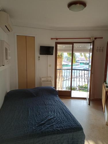 a bedroom with a bed and a sliding glass door at Estudio Caballo-Piscina in Denia