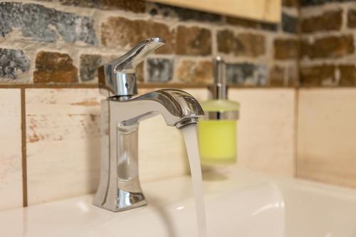 lavandino con rubinetto e bottiglia di sapone di Prázdninový dům Valdík a Loket