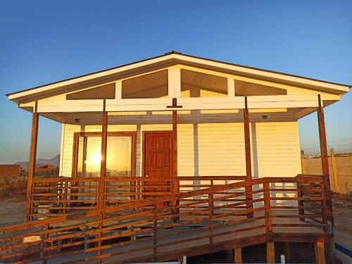 uma pequena casa com um alpendre com o pôr do sol em Atardeceres Tongoy - Cabaña 4 personas condominio privado Tanguemar em Coquimbo