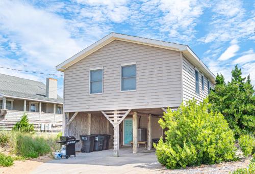 a white house with a gambrel roof at Serendipity - KDH MP 6.5, Oceanfront, Amazing Ocean View, Hot Tub, Pets OK, YR Flex Stays in Kill Devil Hills