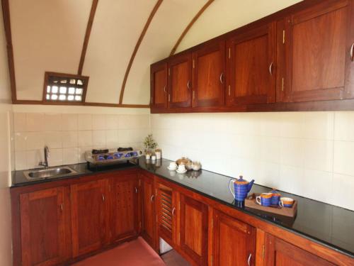 a kitchen with wooden cabinets and a sink at Marvel Cruise in Alleppey
