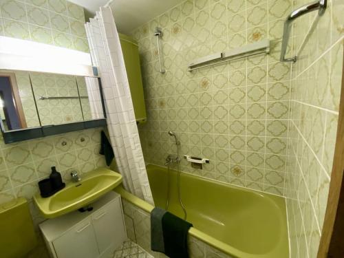 a bathroom with a green tub and a sink at Ferienwohnung nahe der Skipiste im Fichtelgebirge in Mehlmeisel