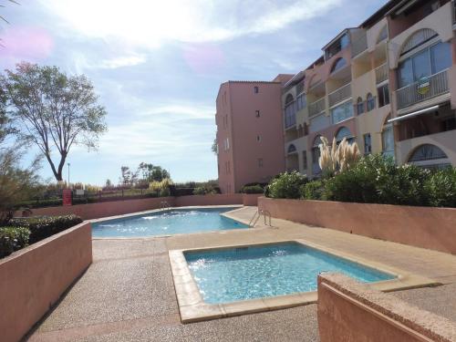 Bazén v ubytovaní AMOUREVA Joli T3 vue mer piscine Cap d Agde alebo v jeho blízkosti