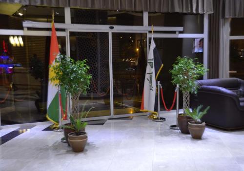 a group of potted plants in front of a building at Hotel Seever in Erbil