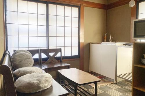 a living room with a chair and a table at 揚羽屋 小諸駅徒歩2分 1日1組限定 ひとりでも泊まれます Agehaya Historical house Center of the town 2minutes walk from Komoro station in Komoro