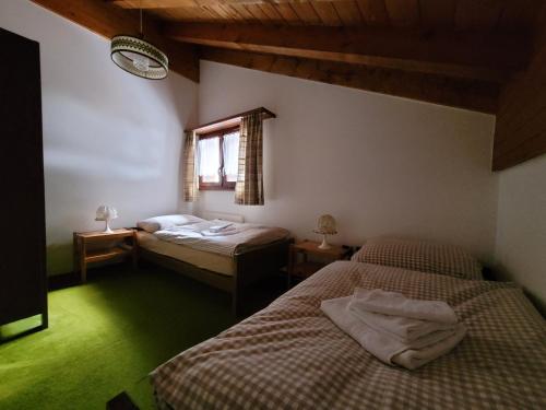 1 dormitorio con 2 camas y ventana en Chalet-Schümli Maisonette, en Ernen