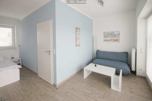 a white room with a blue couch and a table at Marina 22C in Cuxhaven