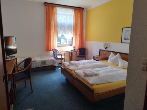 um quarto com uma cama, 2 cadeiras e uma janela em Berghotel Steiger - Erzgebirge em Schneeberg