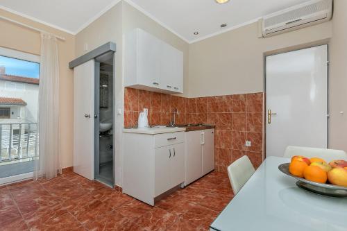 a kitchen with a table with a bowl of oranges on it at Villa NIKA & KARLO Makarska in Makarska