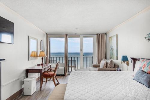 a hotel room with a bed and a desk with a view at Bayside Inn 6682 in Destin