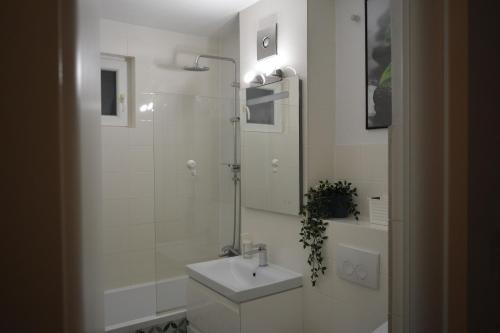 ein weißes Badezimmer mit Waschbecken und Dusche in der Unterkunft M@D Music Apartment in Timişoara