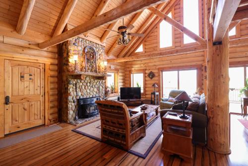 salon z kominkiem w drewnianym domku w obiekcie Beautiful River-Front Log Cabin Near Williamsburg w mieście Toano
