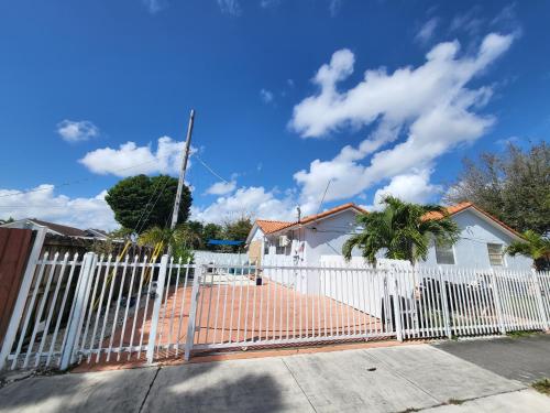 a white fence in front of a white house at Lovely 1-Bedroom Apartment in Miami