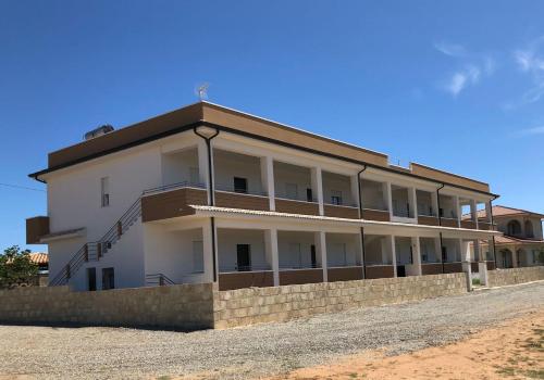 un gran edificio blanco al lado de una carretera en Casa vacanze Capo Rizzuto 1 en Ovile la Marinella