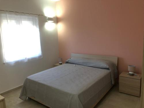 sypialnia z dużym łóżkiem i oknem w obiekcie Casa vacanze Capo Rizzuto 2 w mieście Ovile la Marinella