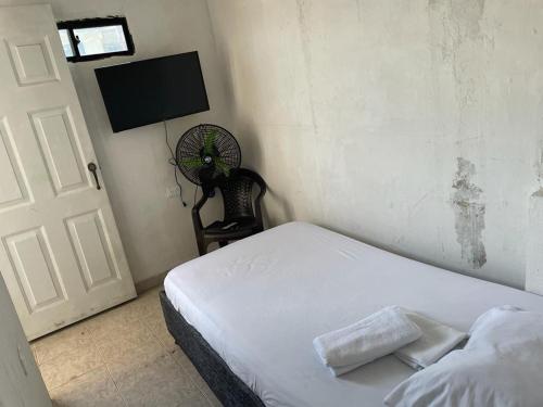 Schlafzimmer mit einem weißen Bett und einem Ventilator in der Unterkunft sophia house in Cartagena de Indias