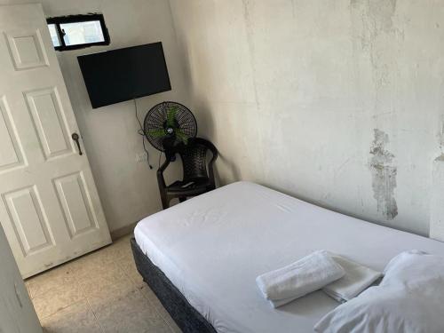 - une chambre avec un lit blanc et un ventilateur dans l'établissement sophia house, à Carthagène des Indes