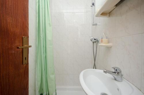 a bathroom with a sink and a shower curtain at Apartments Milan in Poreč