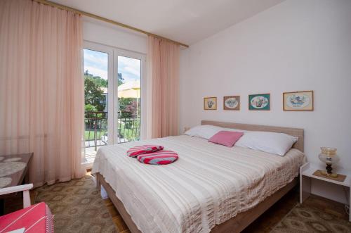 a bedroom with a bed and a large window at Apartments Milan in Poreč