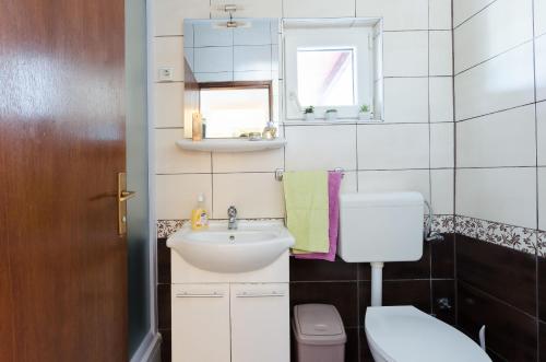 a small bathroom with a sink and a toilet at Apartments Ester in Funtana