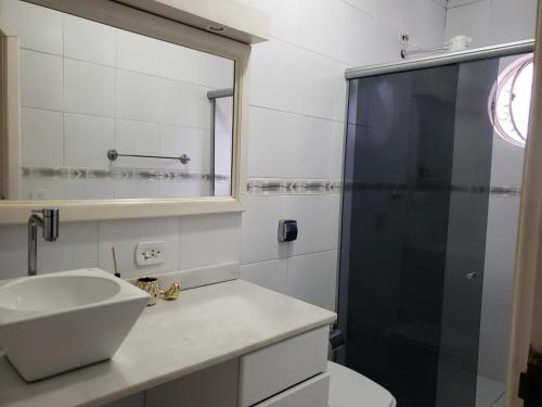 La salle de bains est pourvue d'un lavabo et d'une douche. dans l'établissement Suite Campos do Jordão, à Campos do Jordão