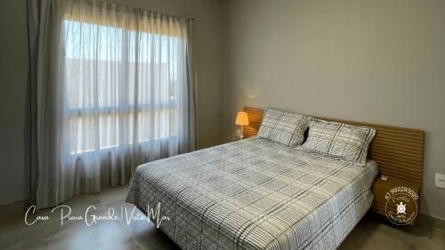 1 dormitorio con cama y ventana grande en Casa confortável com 2 quartos e 1 suíte, pertinho do Mar, Praia Grande - Beto Carrero, Penha SC, en Penha