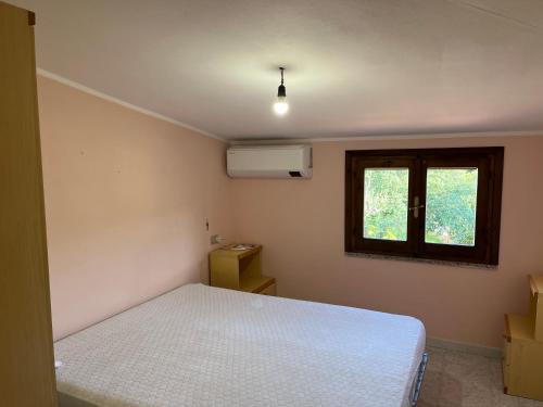 ブドーニにあるCasa Vacanze Cugusiのベッドルーム(白いベッド1台、窓付)