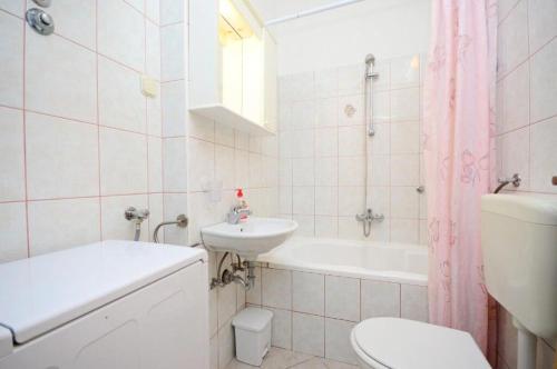 a bathroom with a sink and a toilet and a bath tub at Apartments Bovarovic in Pula