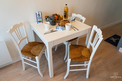 een witte tafel met stoelen en een tafel met eten erop bij Les Beaux Jours, Tours, le Duplex in Tours