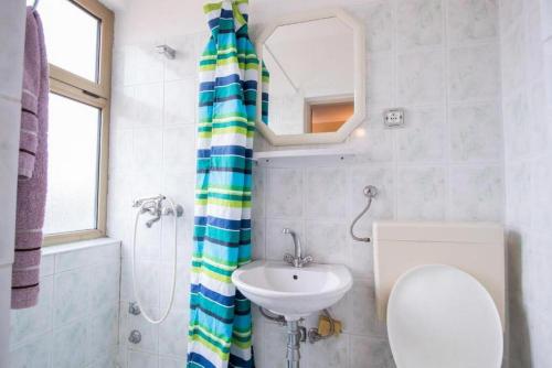 a bathroom with a sink and a toilet and a mirror at Apartments Zeljka in Mundanije